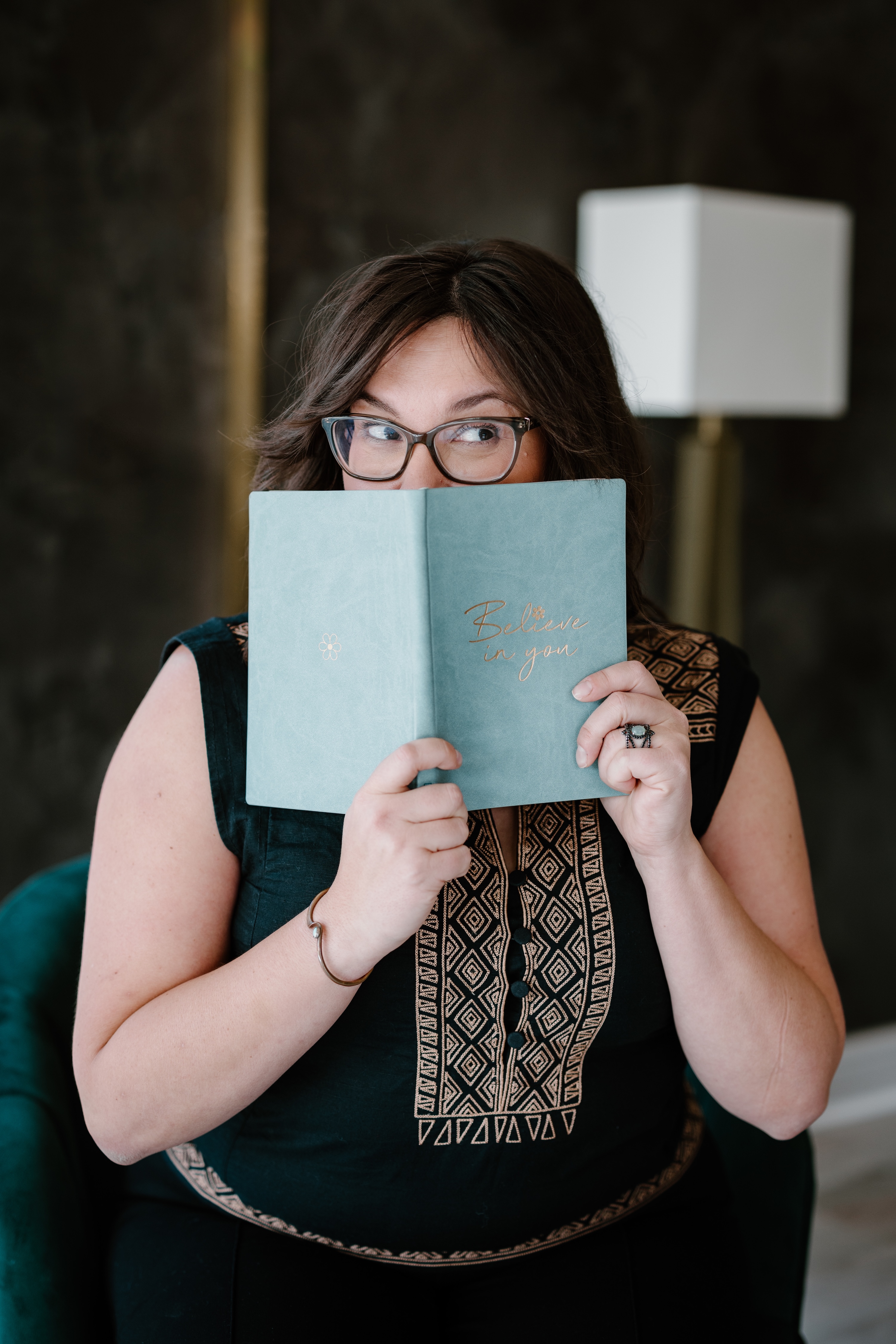 Jessica Paschke holding a journal with a cheeky face.