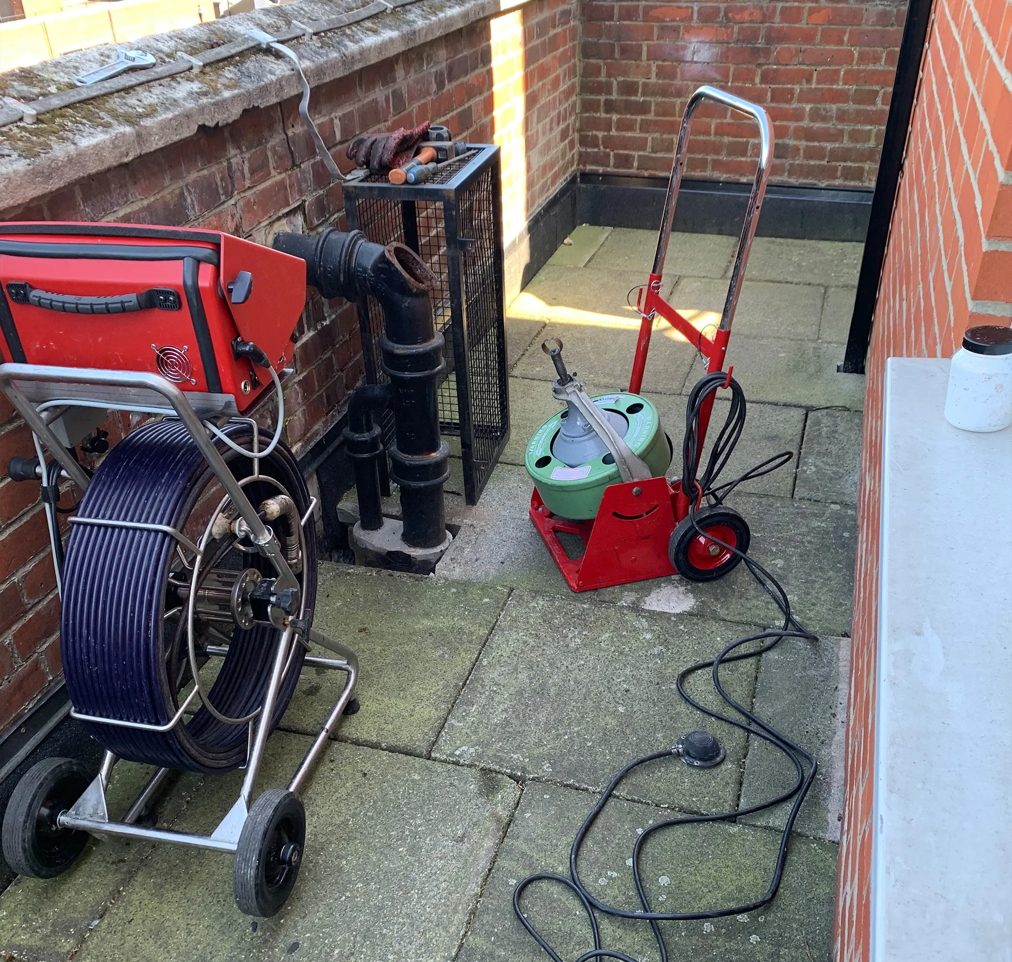 roll of pipe with cctv camera in drain on footpath