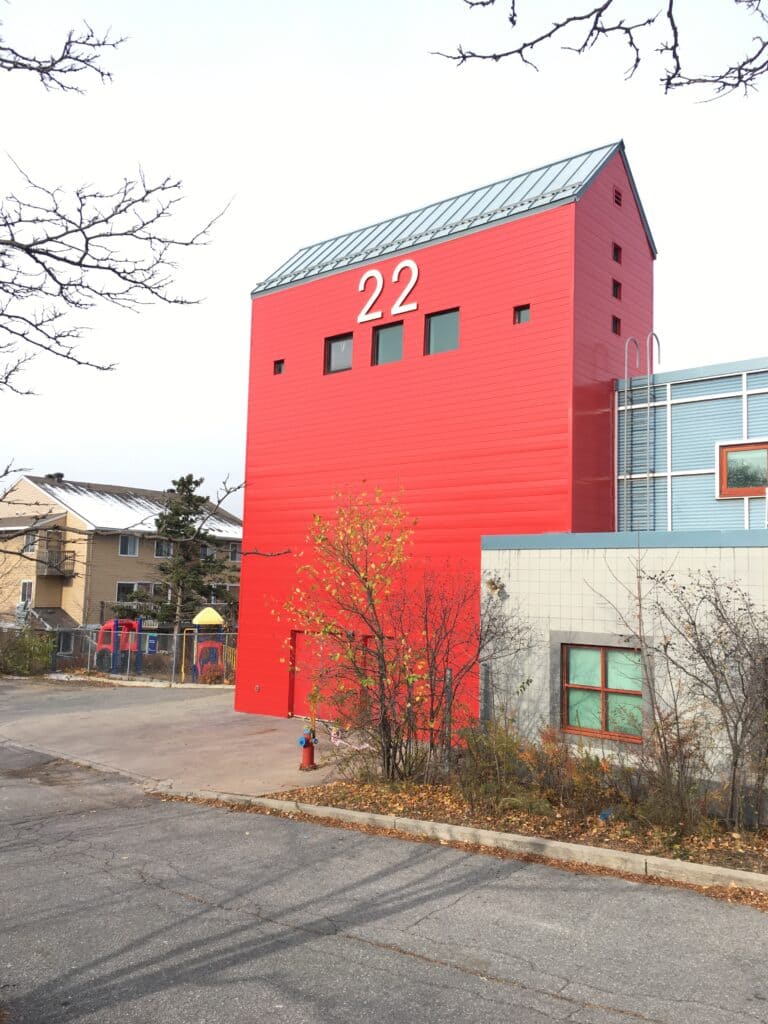 Extension of building featuring vibrant red siding and large 22. 