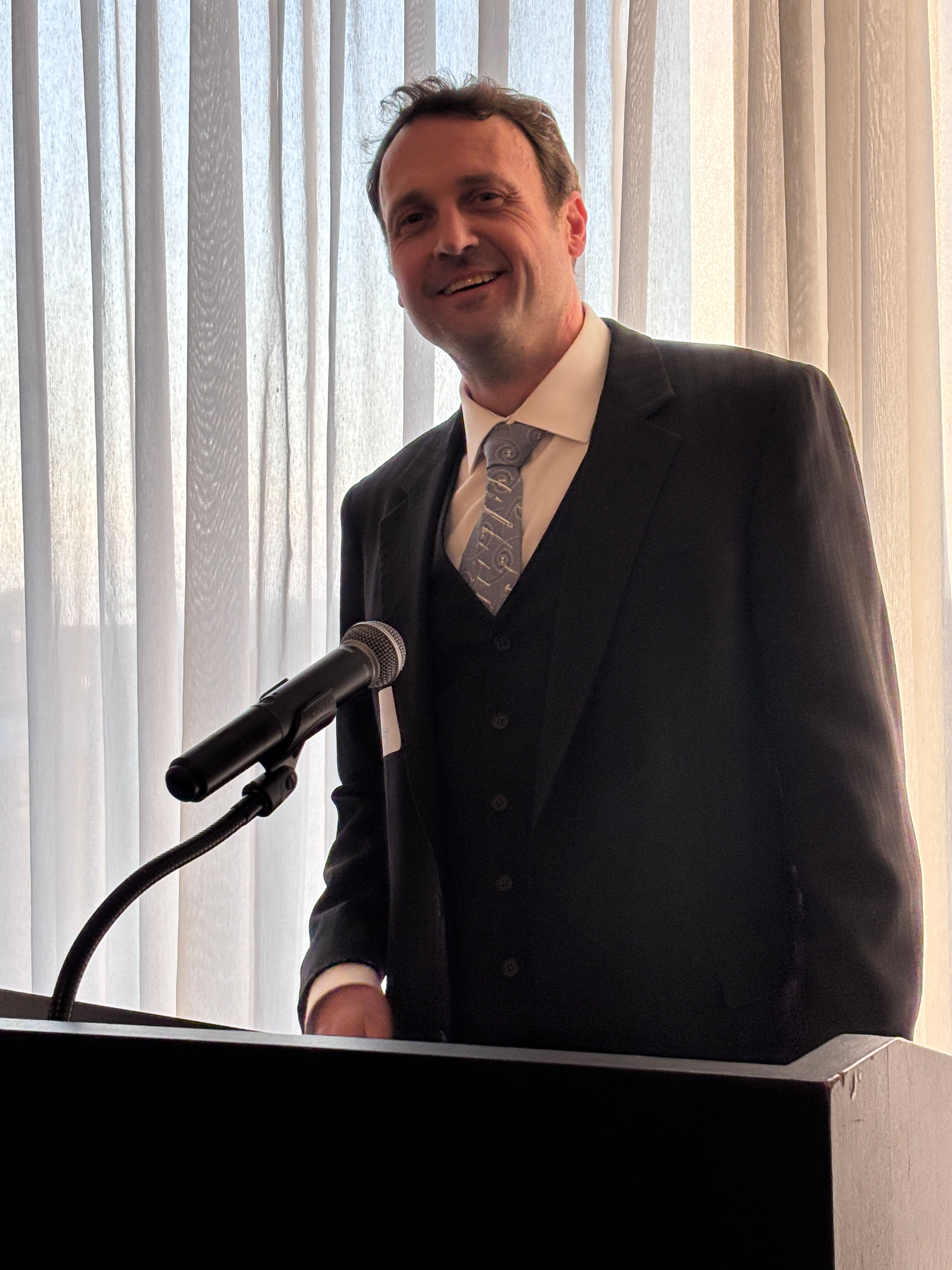 Person speaking at podium during the GCAO Cocktail Reception