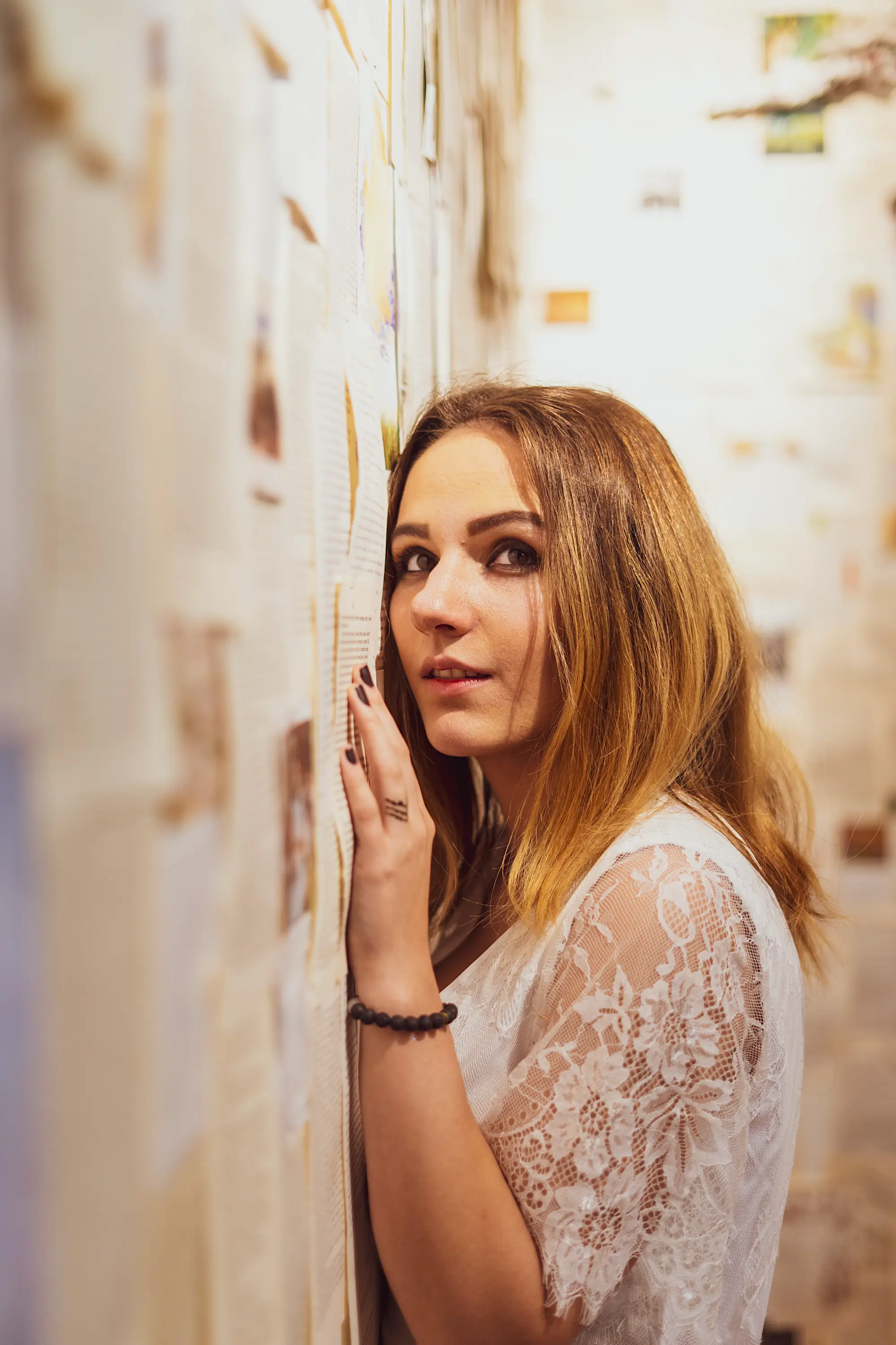 Woman looking at wall of paper from old books