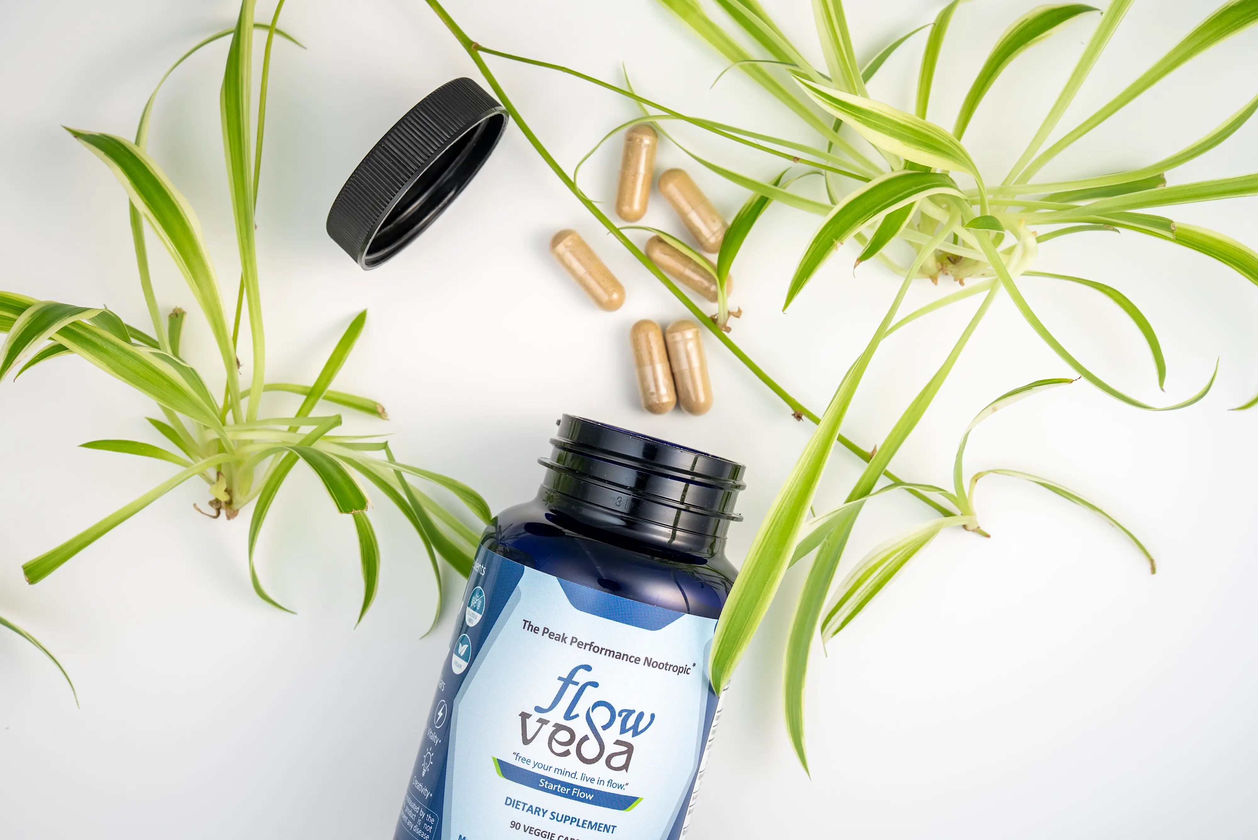 FlowVeda's bottle open on a desk with spilled pills