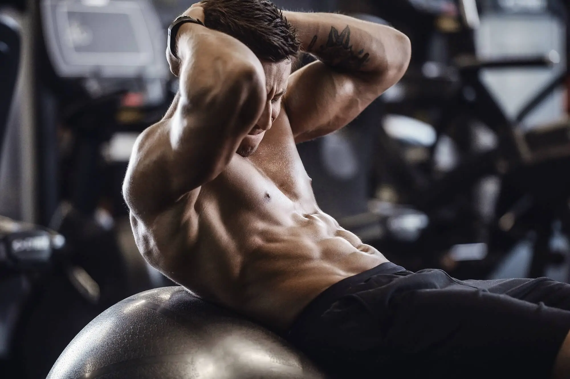 man doing crunches on exercise ball in gym