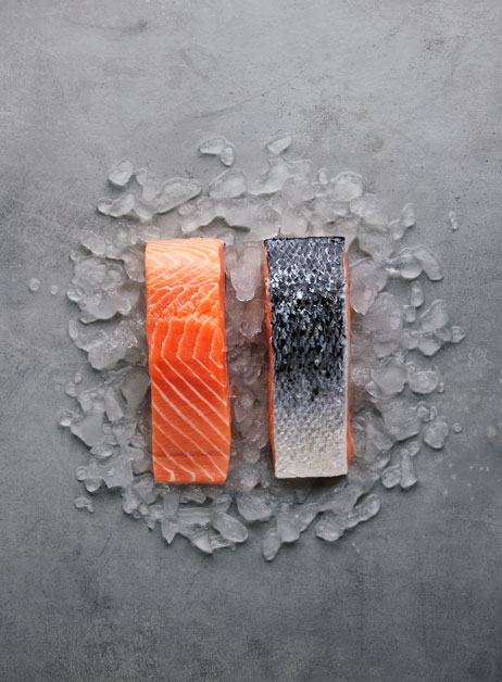 Two peaces of Salmond on top of ice. One of the peaces is from the outside and one is from the inside