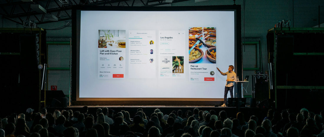 Startup-Präsentation eines Pitch Decks auf großer Bühne mit Publikum