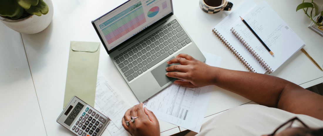 Laptop und Taschenrechner am Schreibtisch – Symbol für Buchhaltung im Start-up und Finanzorganisation im Alltag.
