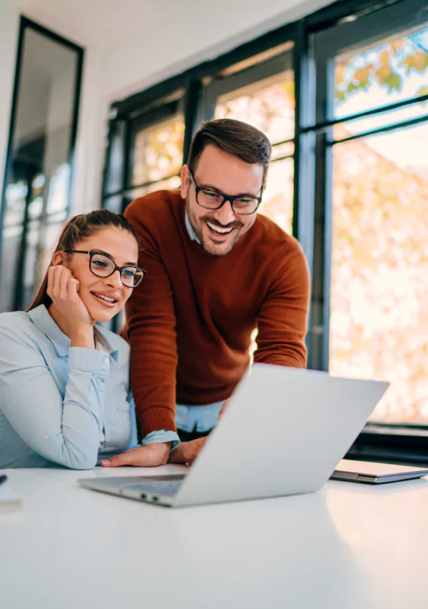 a man and a woman looking at a laptop