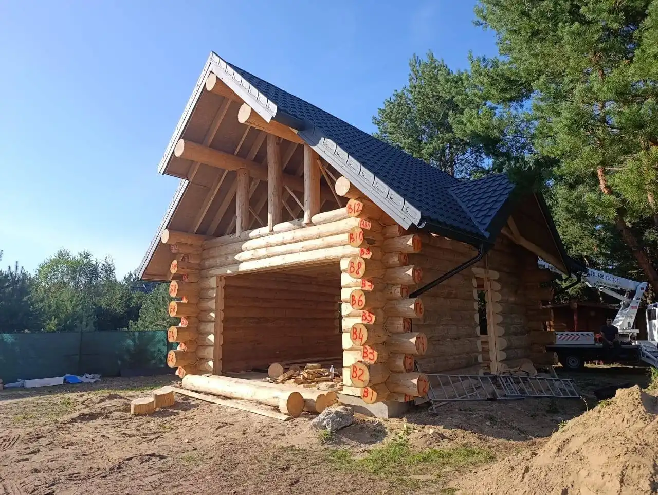 Dom z bali świerkowych w stanie surowym otwartym, naturalne bale przed ręcznym szlifowaniem i impregnacją, budowa tradycyjnego domu z drewna