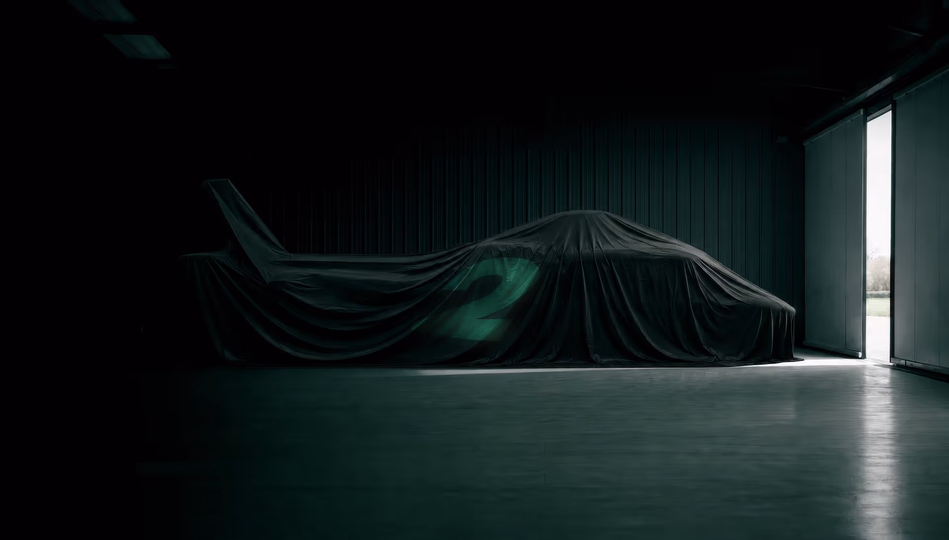 Helicopter covered with a dark cloth showing a glowing number 2 in a dim garage by an open door.