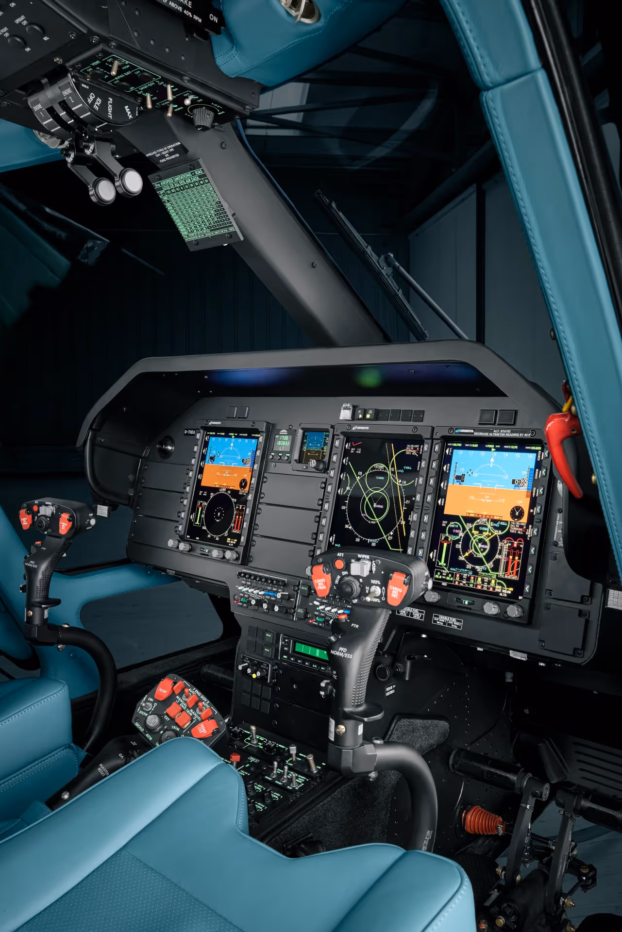 Modern aircraft cockpit with blue seats and digital flight instrument displays on control panel.