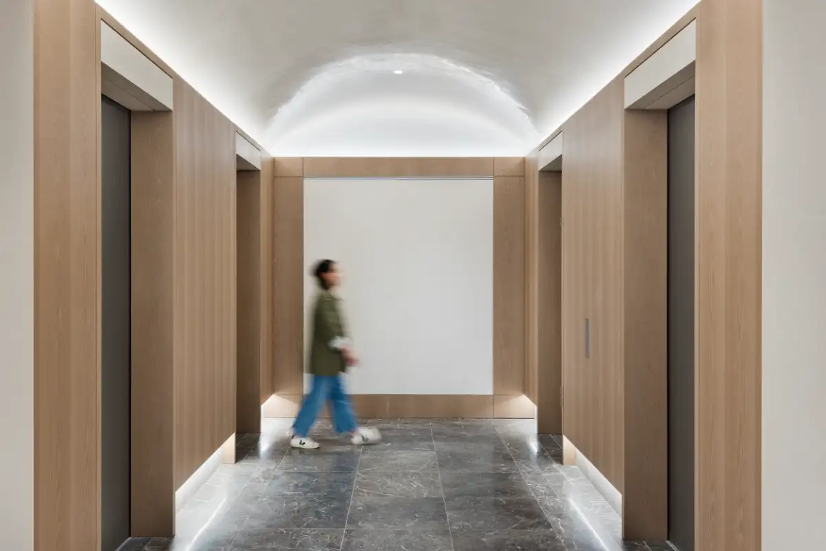 Spectorgroup-designed Park 53 elevator lobby with vaulted plaster ceiling, oak wood paneling, and gray marble floor