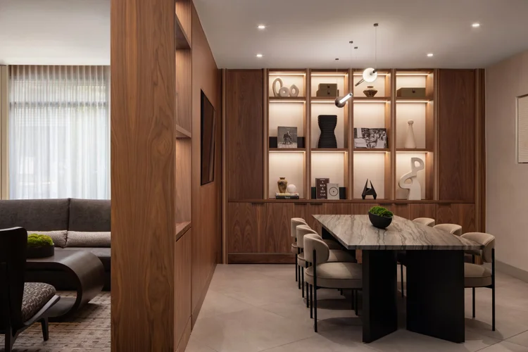 3877-designed AC Hotel dining nook with backlit walnut shelving, marble table, upholstered chairs, and curved lounge seating