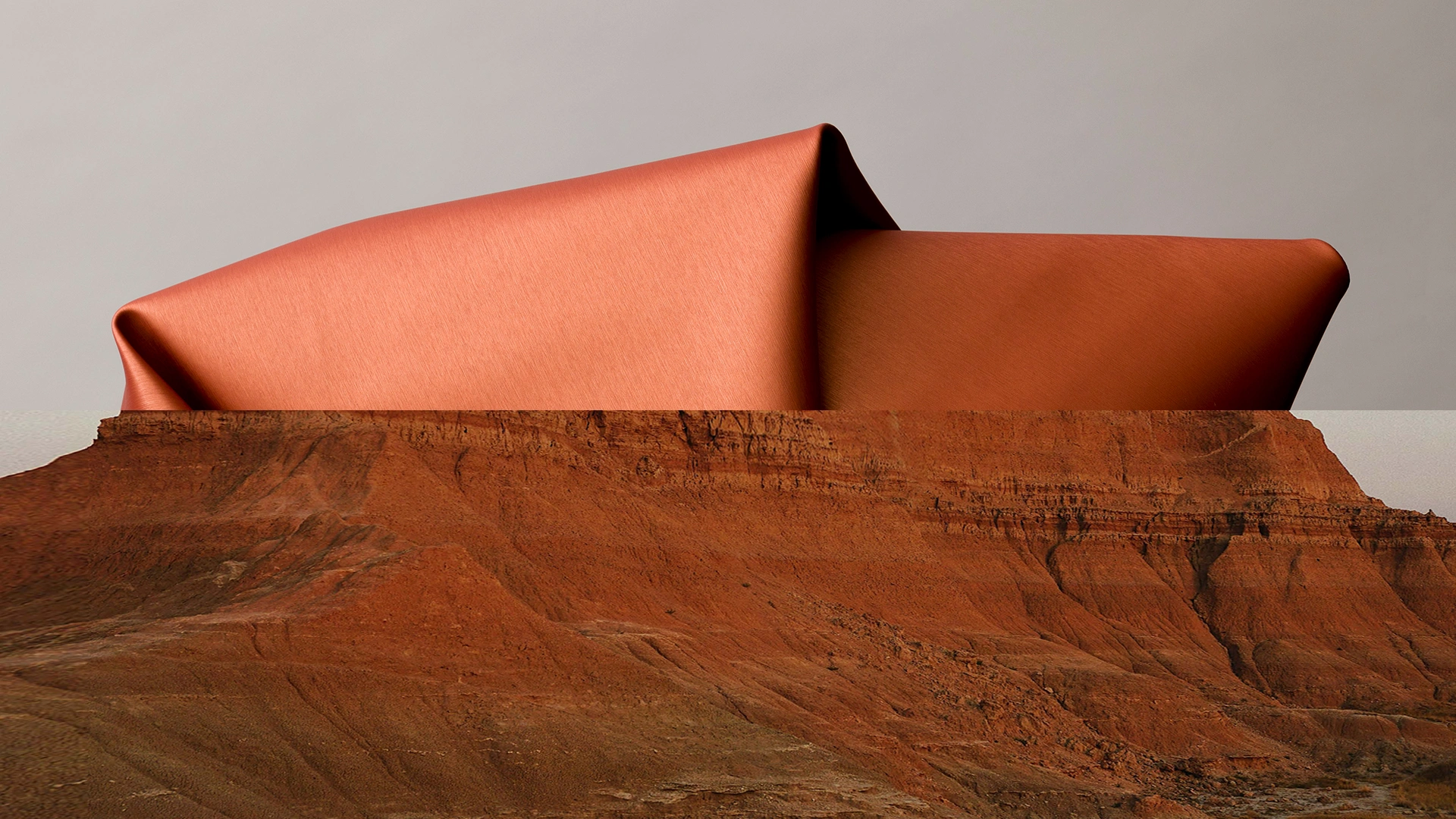 Fil Doux sustainable textile in terracotta draped over red rock canyon landscape illustrating the brand's connection to nature and material craft