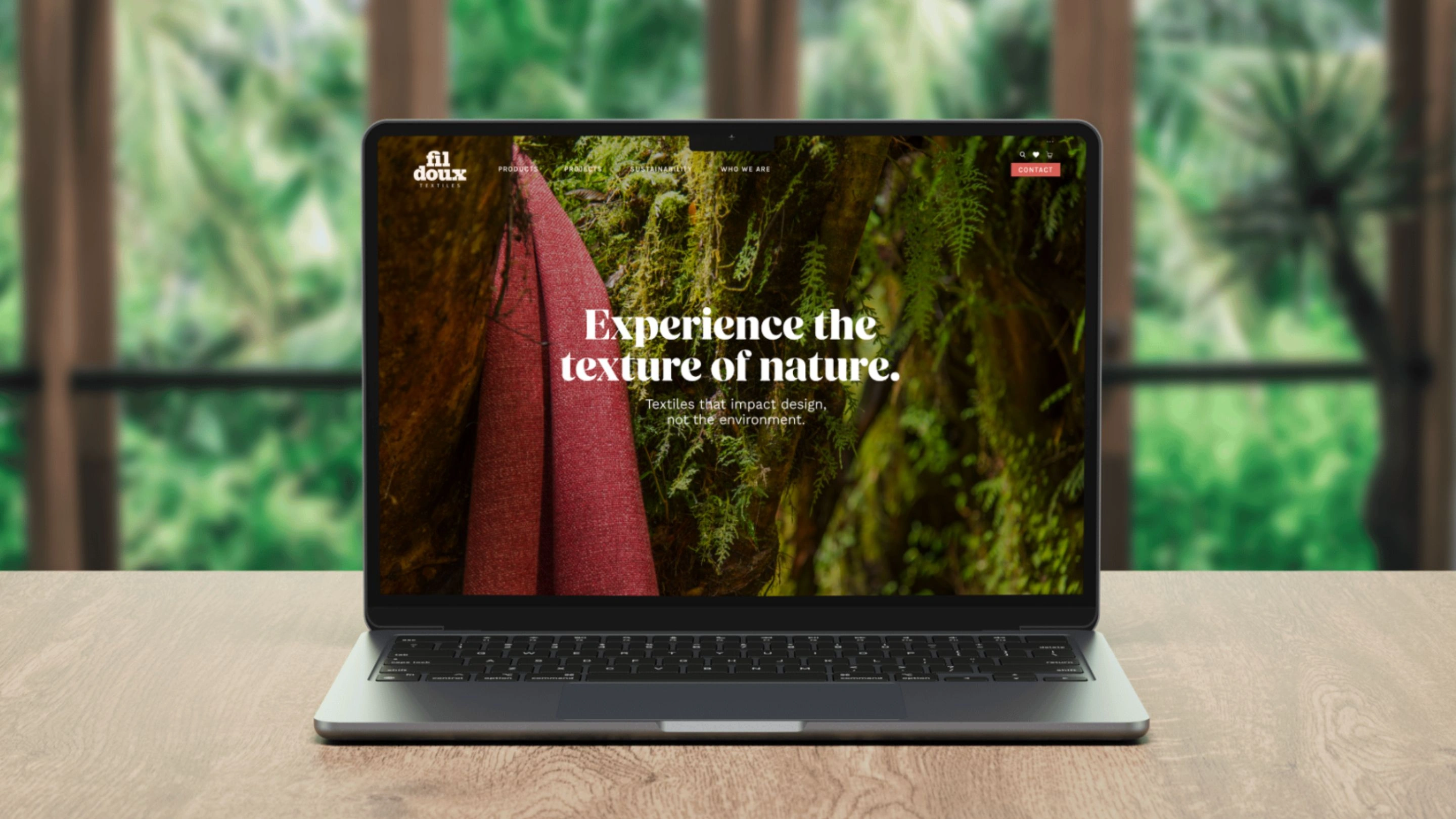 Fil Doux Textiles website homepage displayed on a laptop, featuring a red fabric draped in a rainforest setting