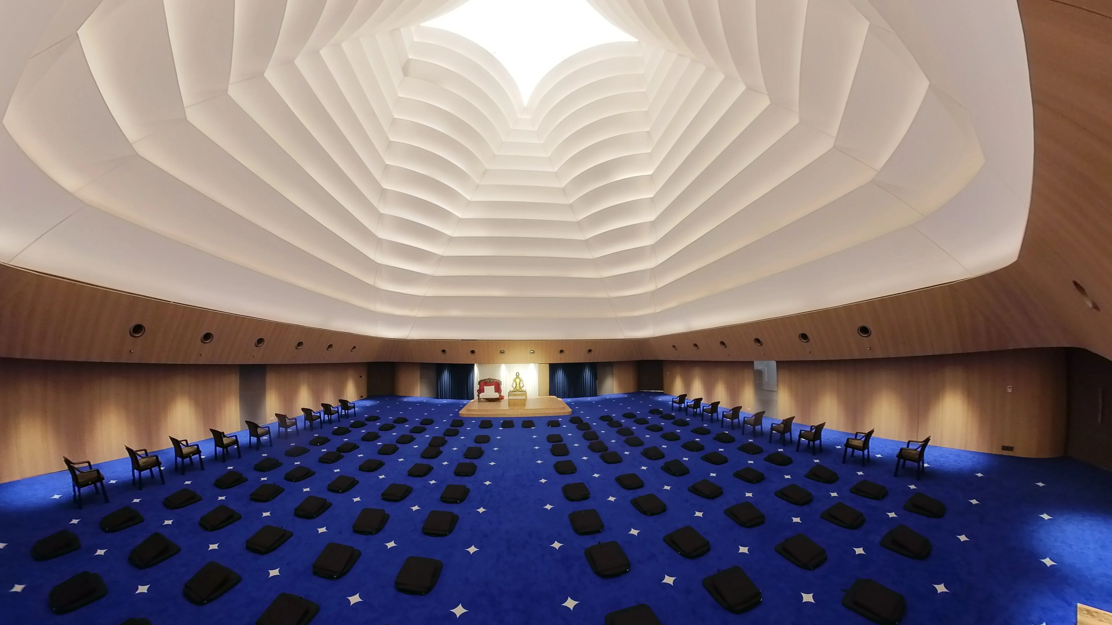 Serge Ferrari architectural membrane structure creating a sculptural pleated ceiling with skylight in a meditation hall