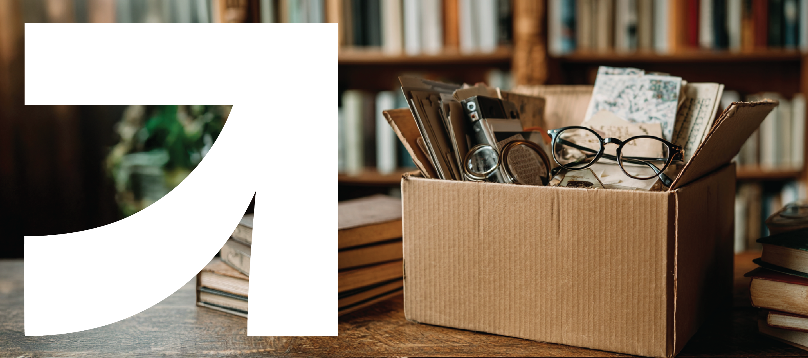 A small box og books and papers sits on a table in a library. UpSpring logo to the left.
