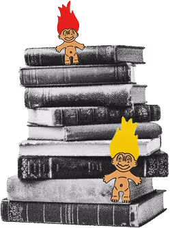Vintage troll dolls with fiery hair perched on stack of old books