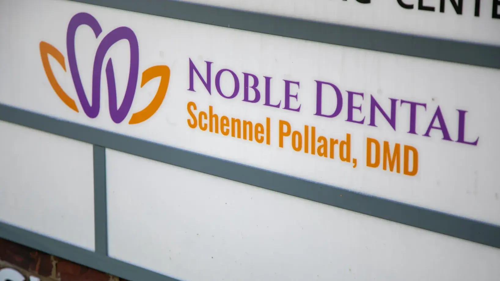 Sign for "Noble Dental," featuring the name "Schnell Pollard, DMD" with a purple and orange logo.