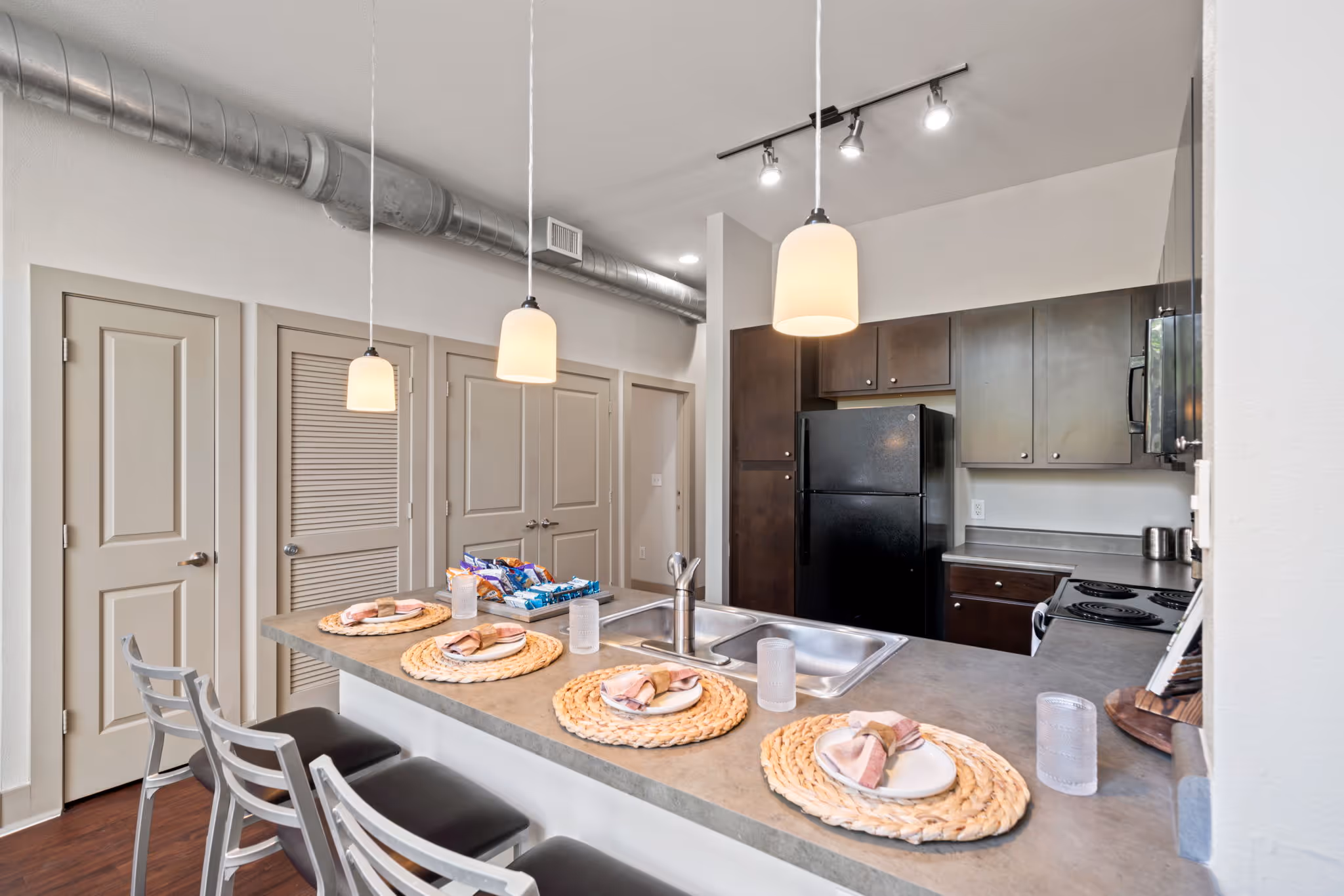 Kitchen breakfast bar styled with place settings, highlighting the social layout of the floor plan.