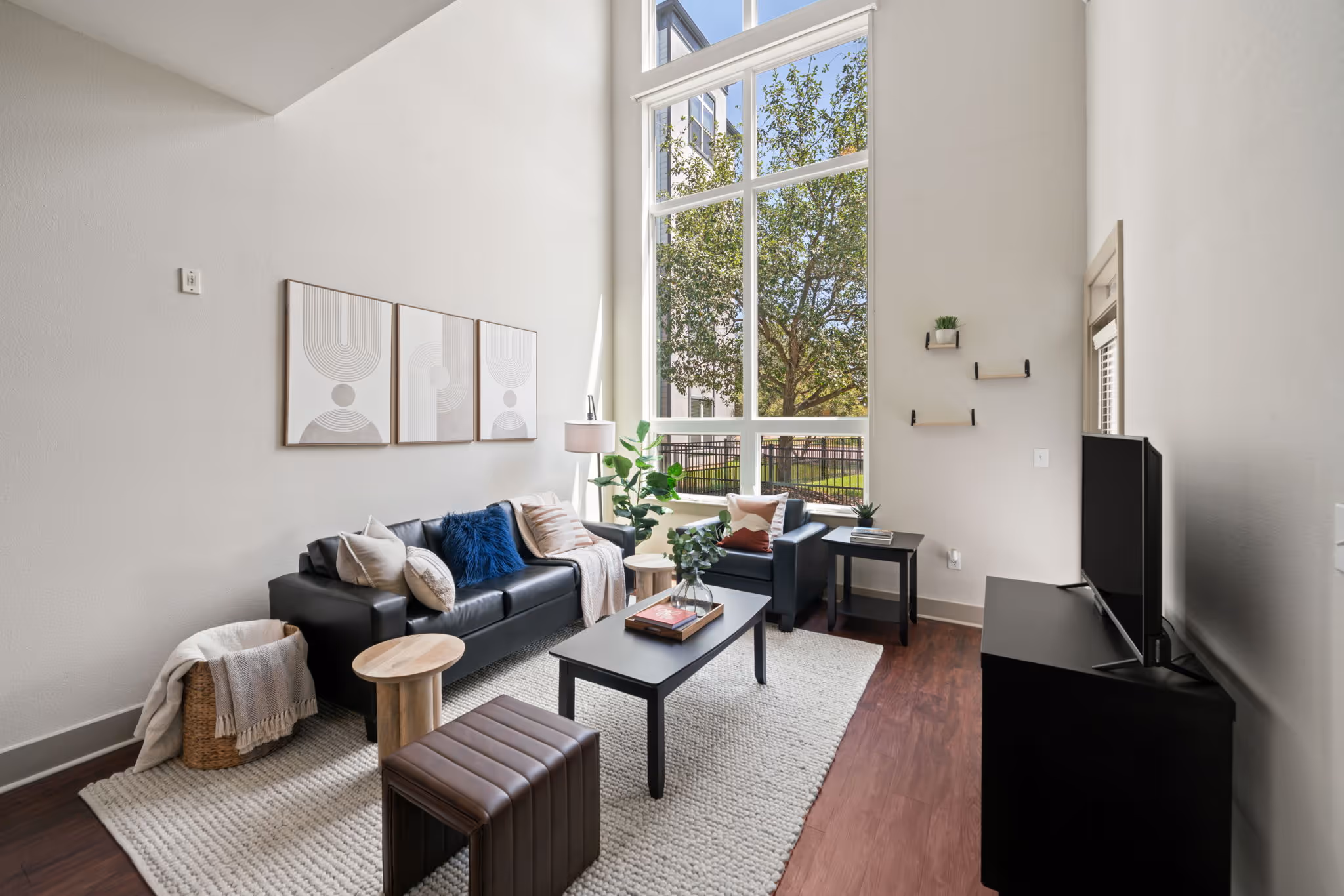 Living room with plush seating, modern art, and a view of the College Station landscape.
