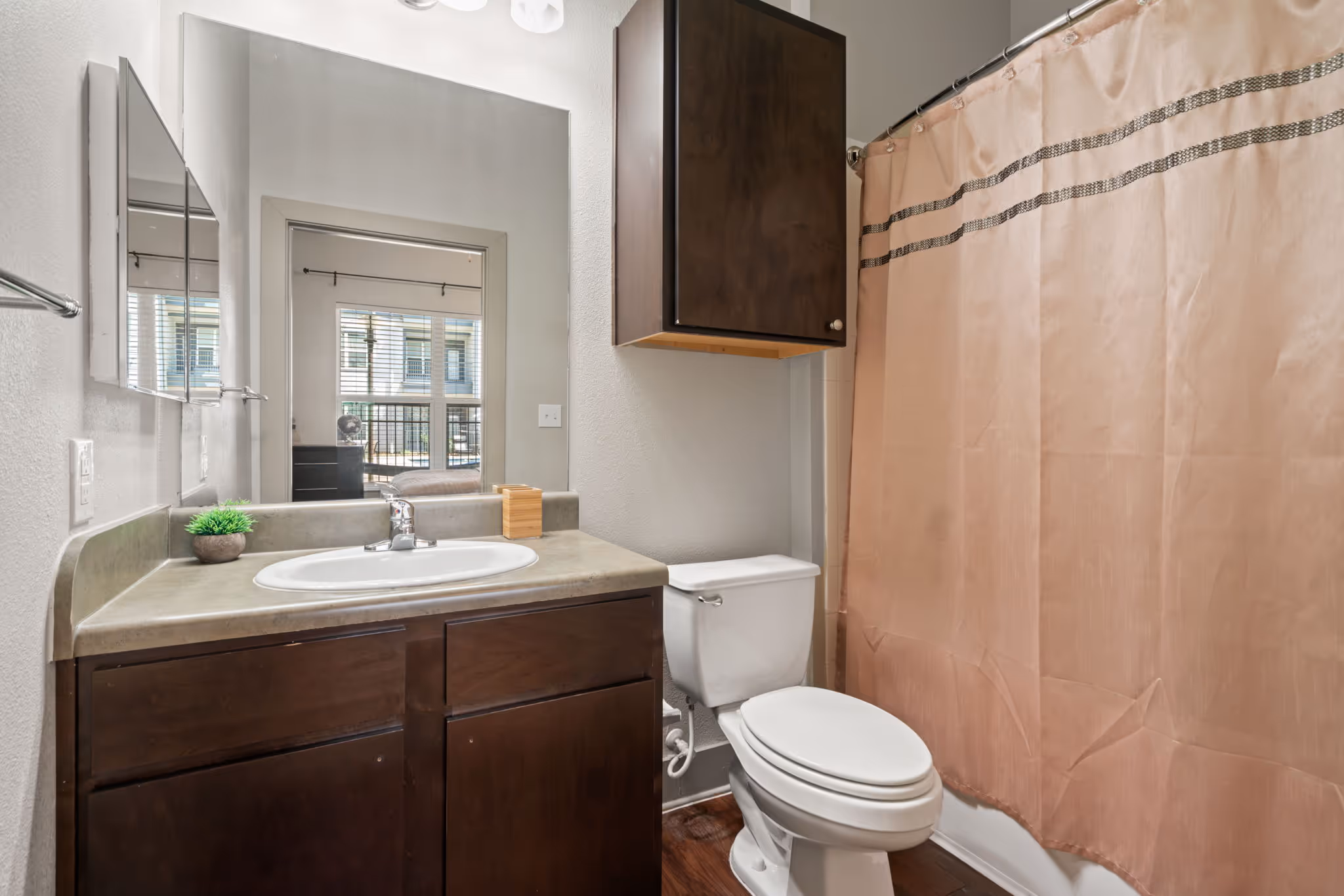Bathroom with vanity area with a modern sink and warm lighting fixtures at The Lofts at Wolf Pen Creek.