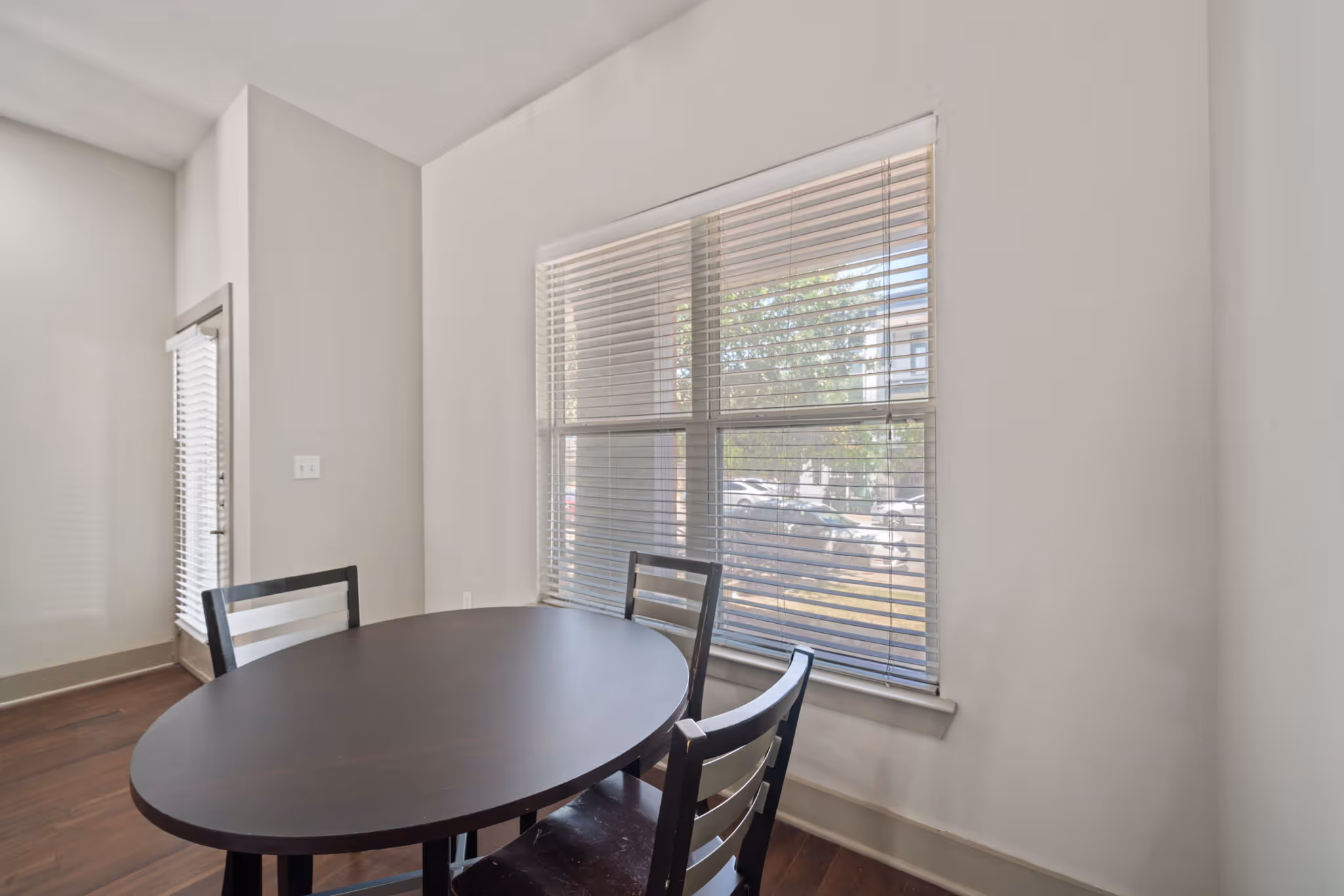 Cozy dining nook layout with large window looking out to the street in the College Station apartment floor plan at The Lofts at Wolf Pen Creek.