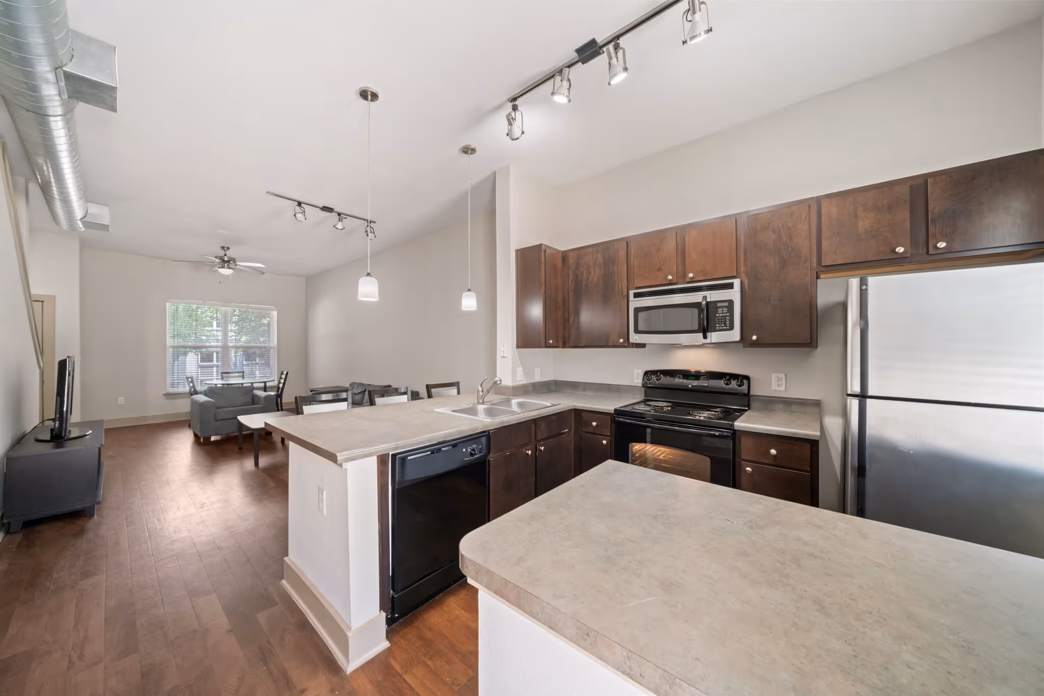 Wide view of the functional kitchen and adjacent living space at The Lofts at Wolf Pen Creek.