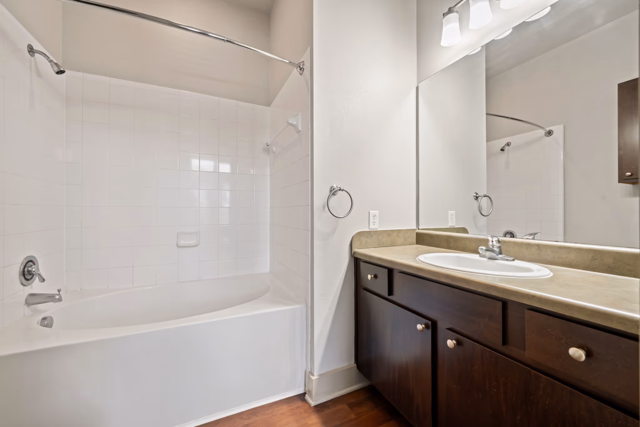 Functional apartment bathroom at The Lofts at Wolf Pen Creek with a wide vanity and bright lighting.