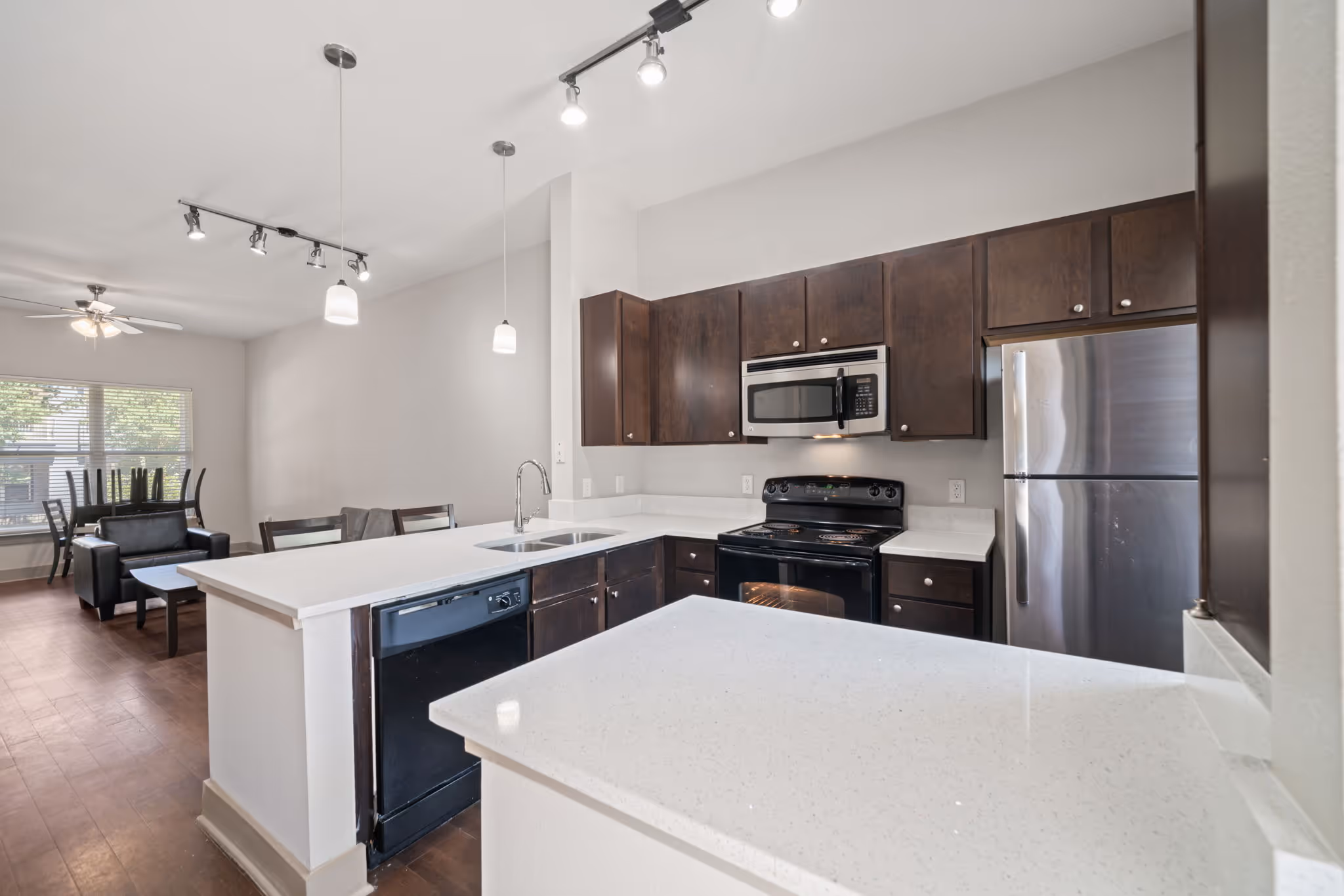 View of the open-concept living area from the kitchen, showcasing the flow of The Lofts at Wolf Pen Creek floor plan.