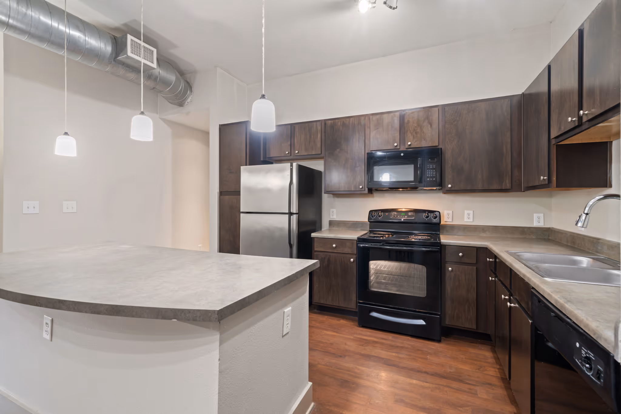 Detailed view of the kitchen's dark cabinetry and modern black appliances at apartment in College Station.