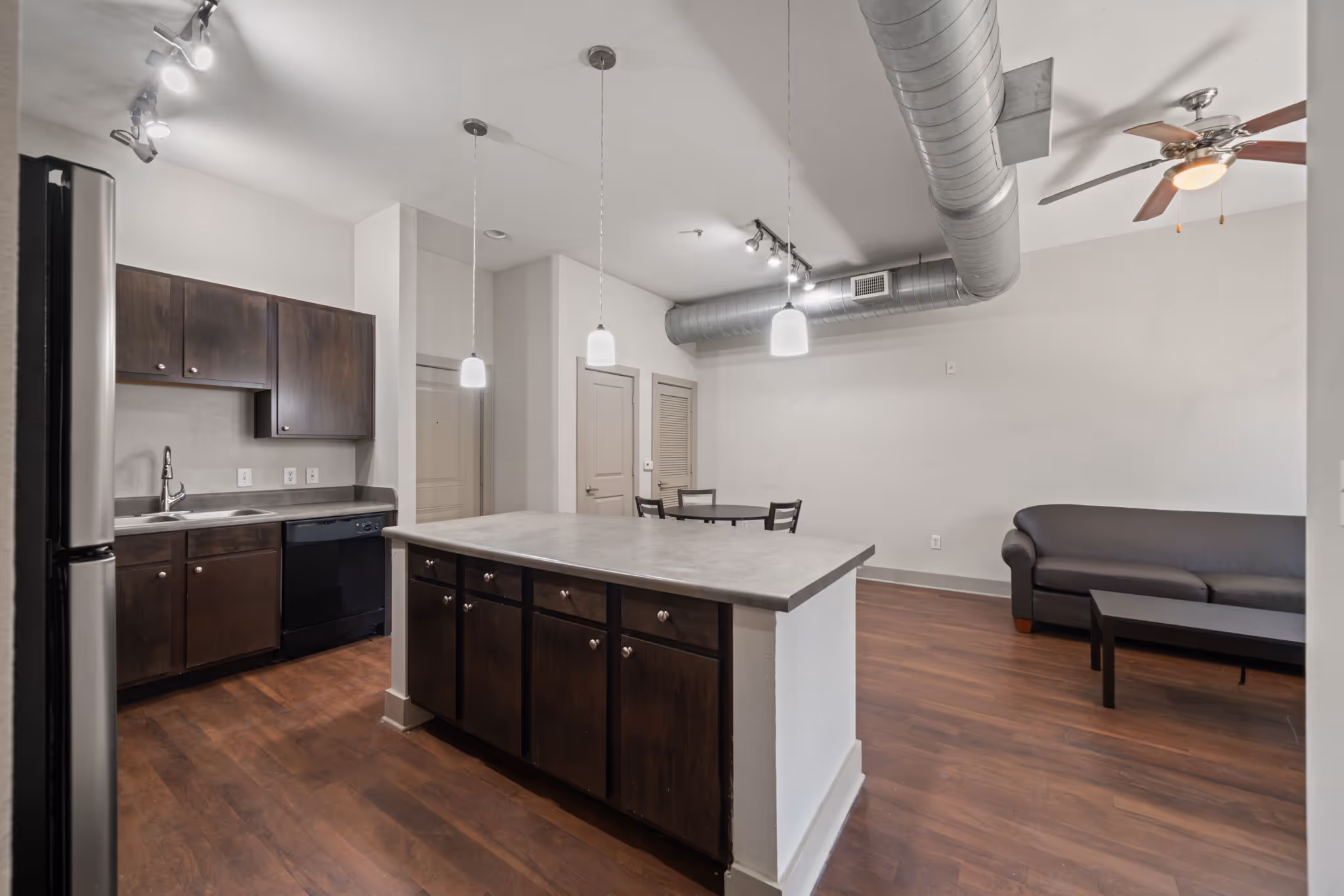 Expansive living area layout showing the breakfast bar and transition to the living room area in an apartment at The Lofts at Wolf Pen Creek.