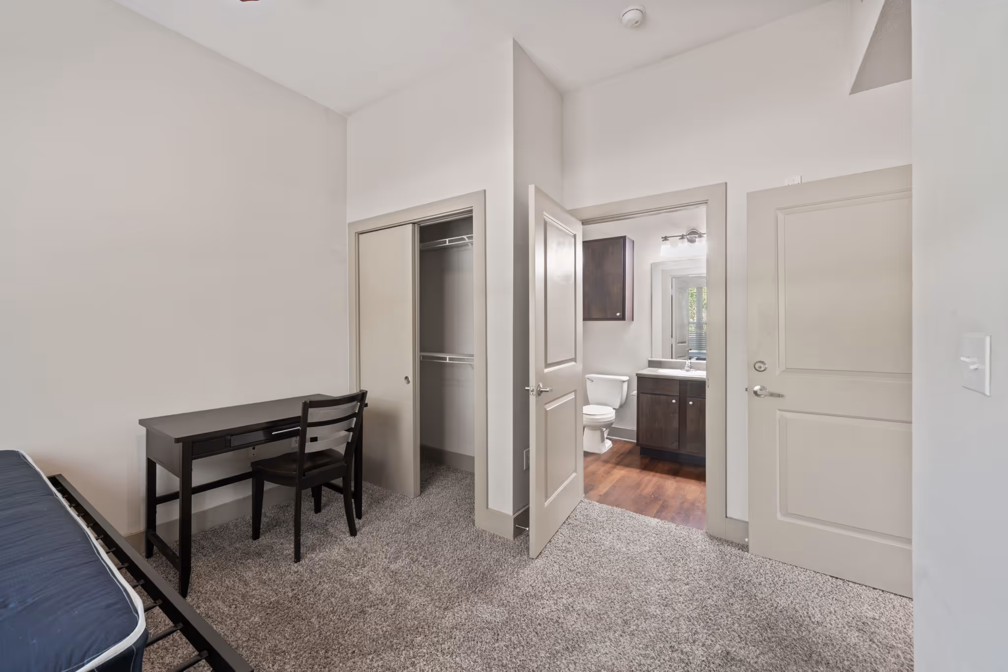 View from a bedroom looking into the attached bathroom and walk-in closet space at The Lofts at Wolf Pen Creek.
