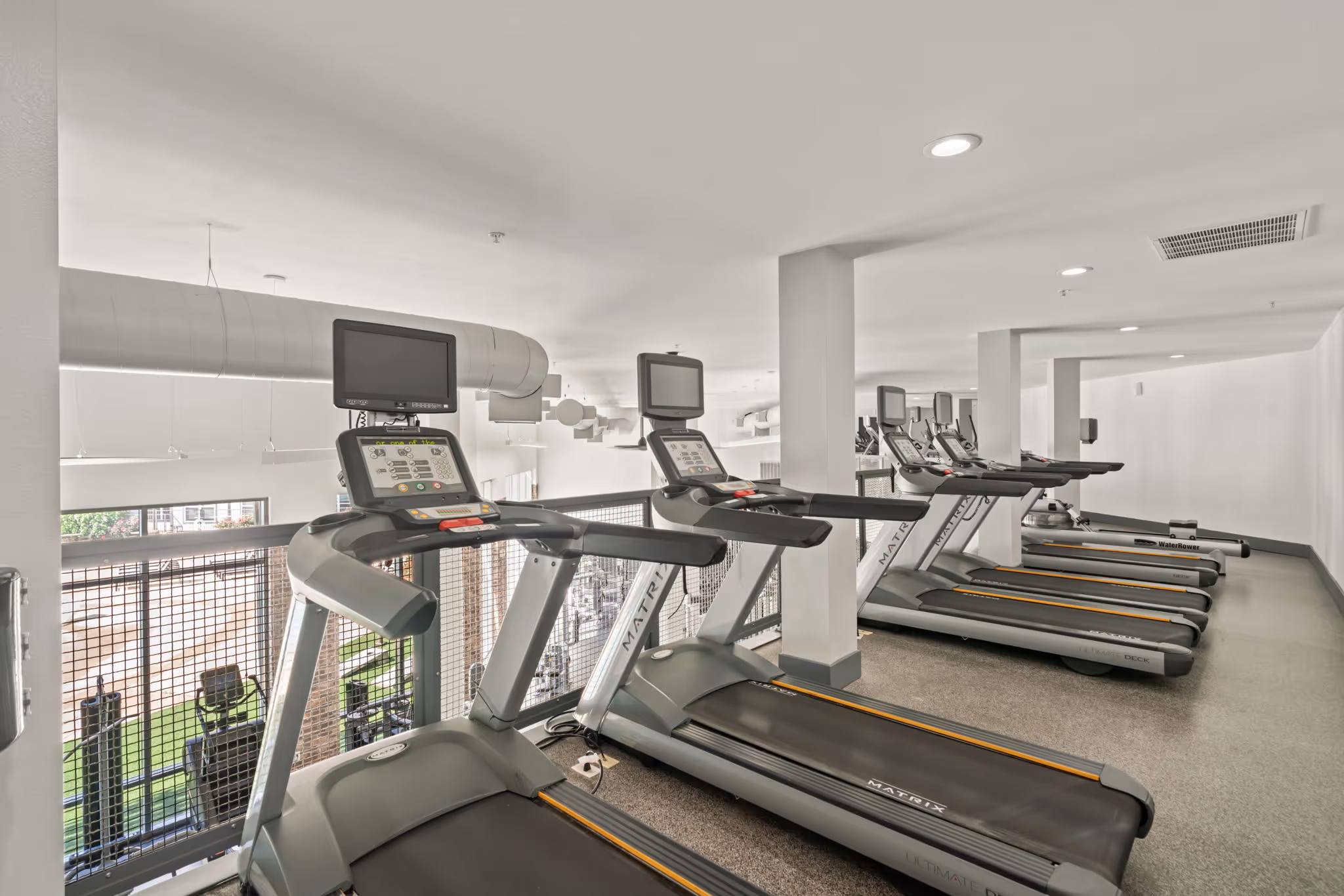 Cardio section with Matrix treadmills overlooking the fitness center at The Lofts at Wolf Pen Creek.