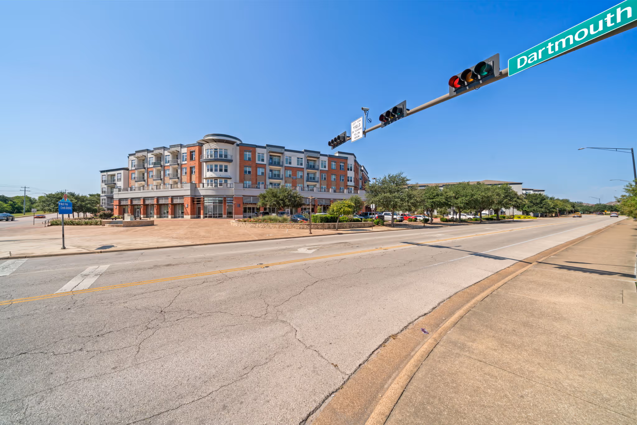 Street view of The Lofts at Wolf Pen Creek apartment community located at the corner of Dartmouth Street in College Station.