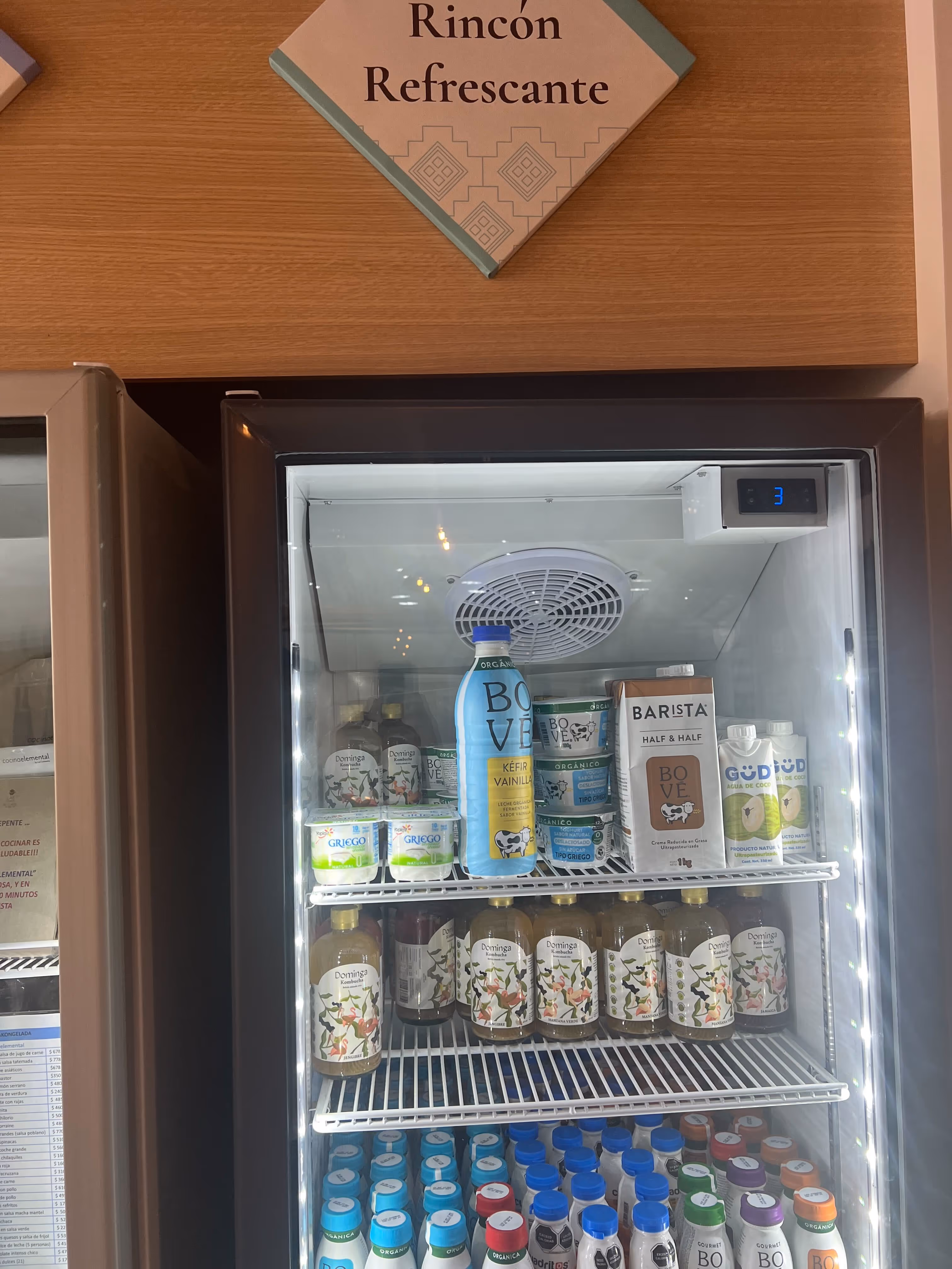 Refrigerador con bebidas y productos lácteos orgánicos y naturales, incluyendo kéfir, kombucha y agua de coco.