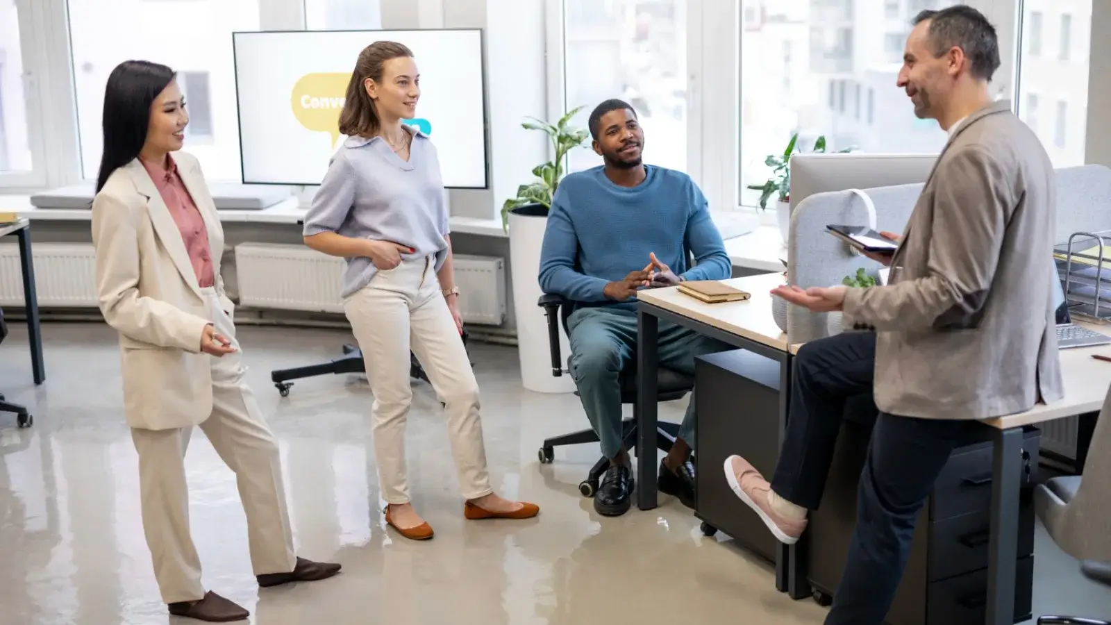 Group of professionals discussing hiring strategies in an office.