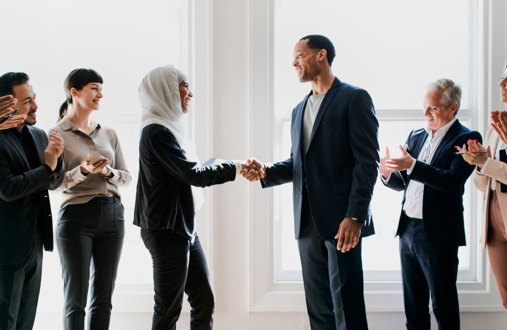 Professionals shaking hands in a collaborative setting.