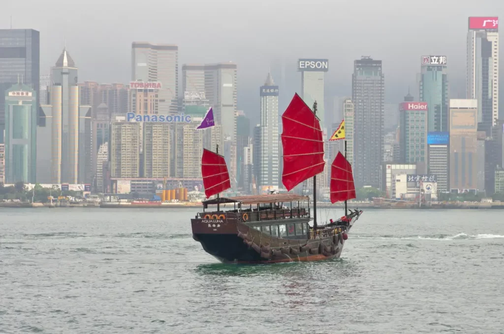 Traditional Chinese junk boat sailing in Hong Kong harbor.