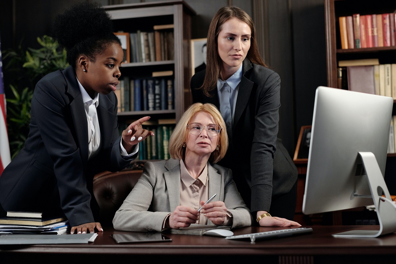 Three business professionals collaborating in an office setting.