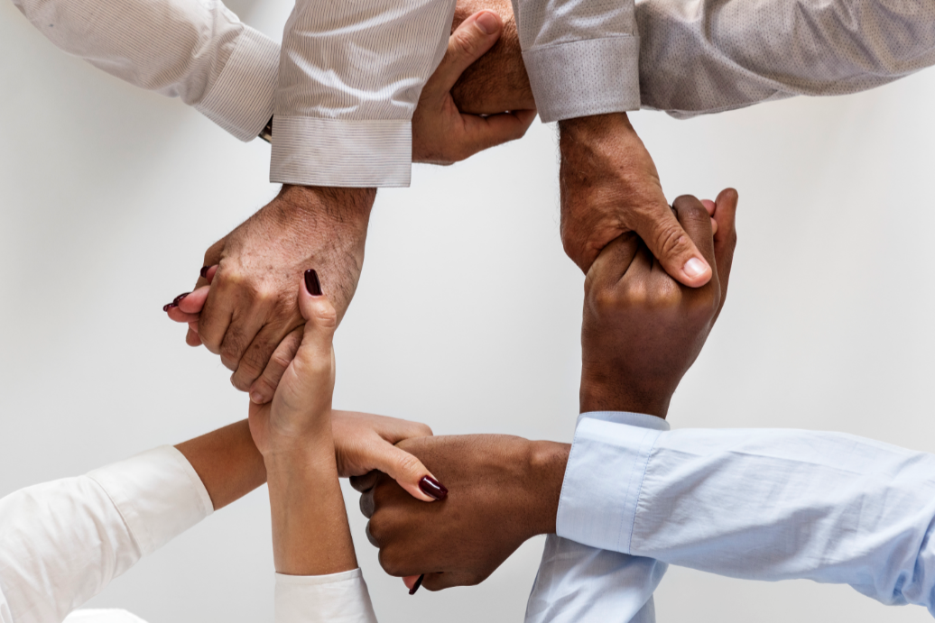 Diverse group of hands clasped together in unity.