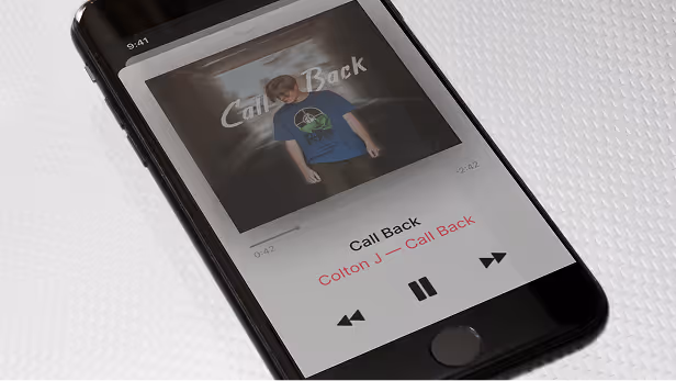 Smartphone screen displaying a music player with album cover by Inlumina Creative.