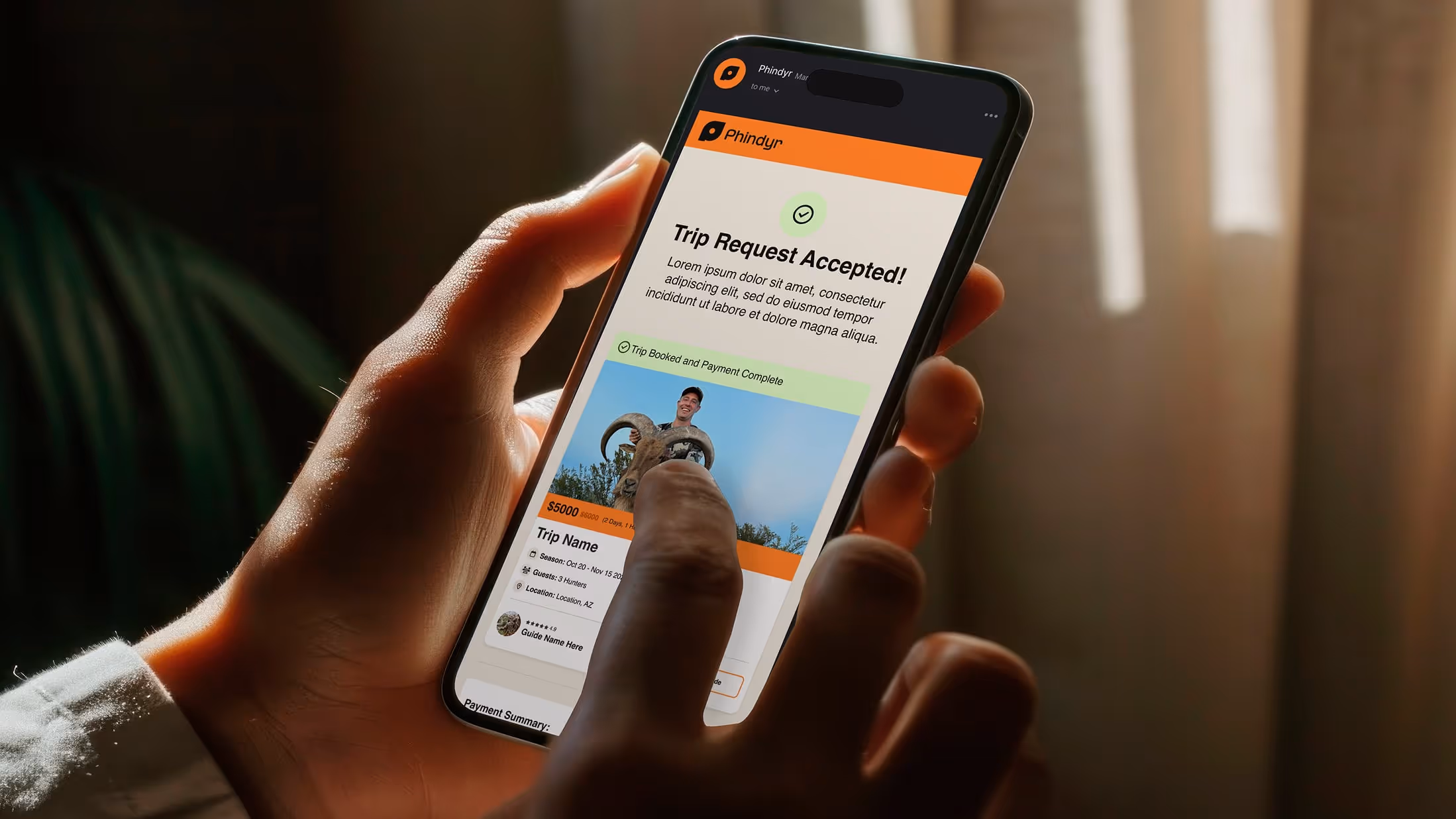 Hands holding iphone scrolling through a Phindyr email