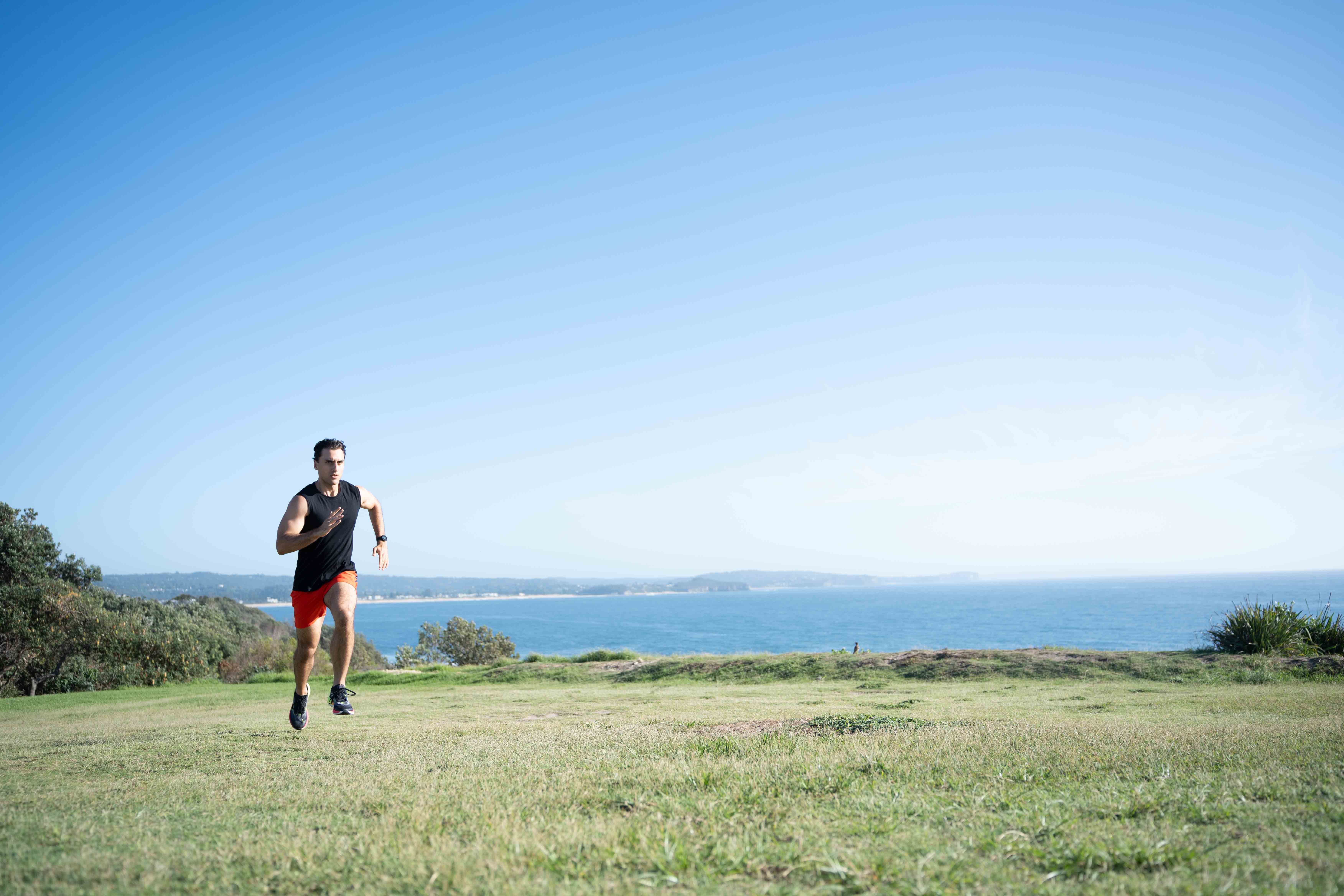 Man running uphill with proper biomechanics 