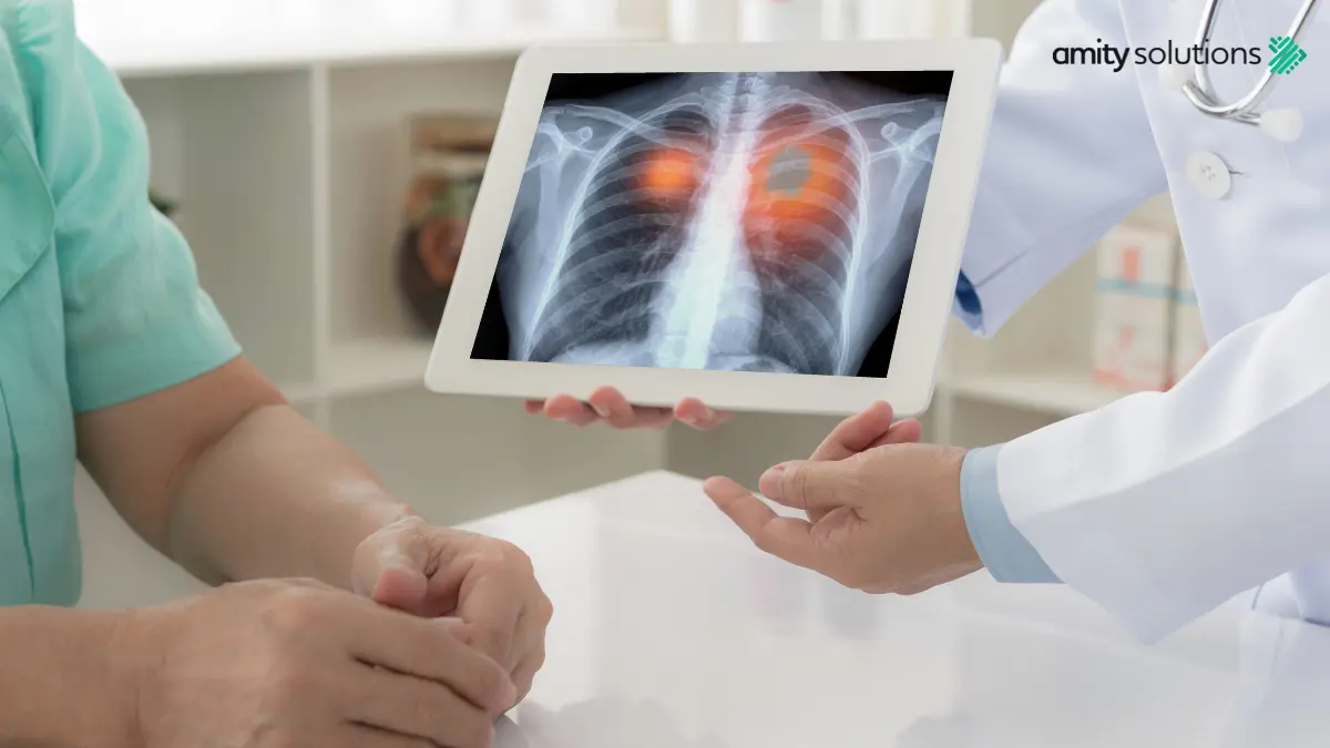 Doctor in white coat showing chest X-ray on tablet to patient, with orange highlighting on lungs indicating potential medical condition