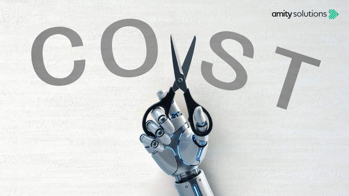A robotic hand holding scissors cuts through the word "COST" against a white textured background, with the Amity Solutions logo in the top right corner — representing how AI technology helps businesses reduce costs.