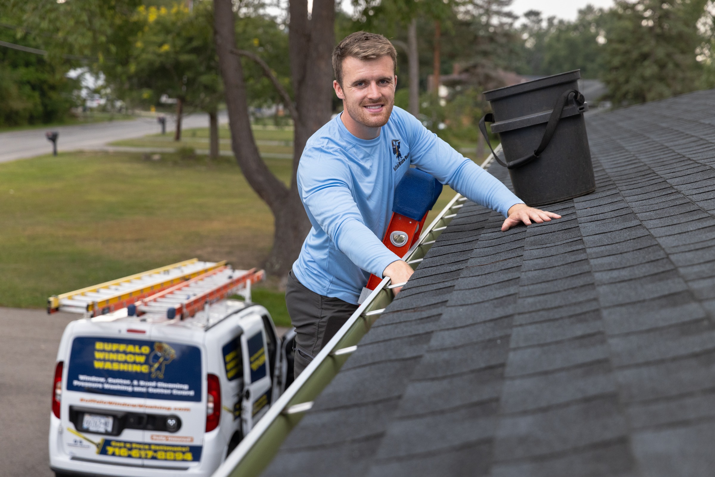 Technician smiling white cleaning gutters