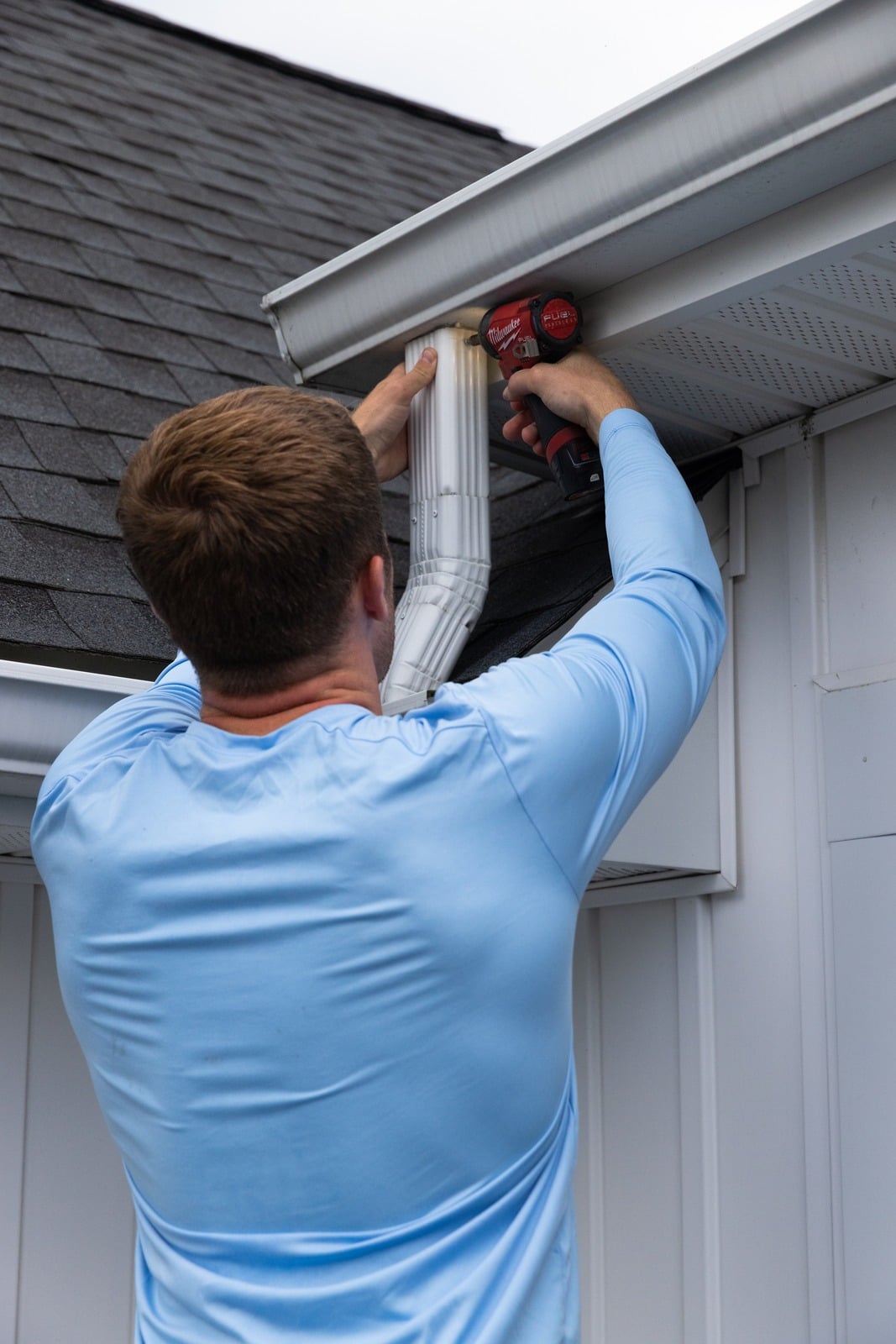 Technician working on downspout of gutter