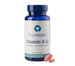 A sealed bottle of vitamin-B12 stands beside a loose capsule.