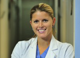 Dr. Jaime Snarski smiling in front of a door.