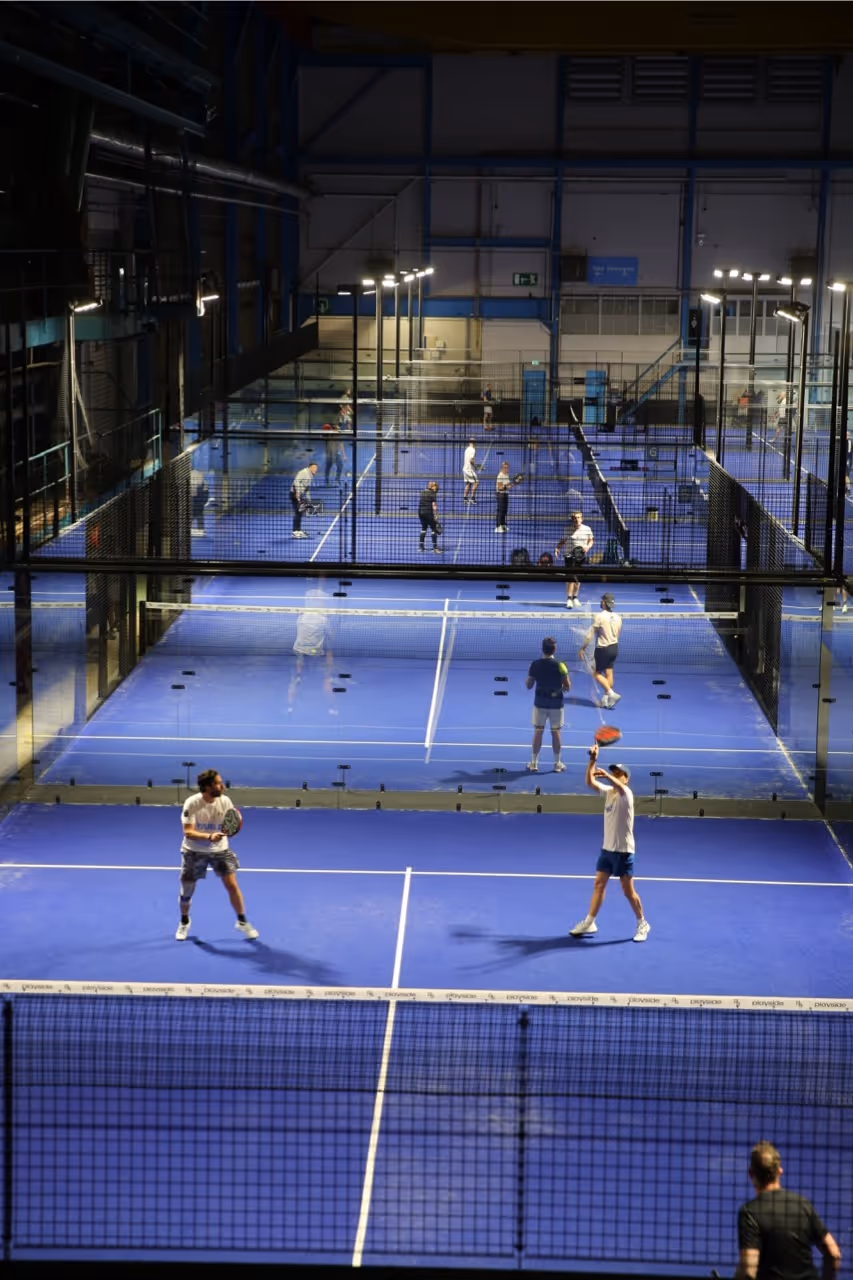 Overzichtsfoto van alle padelbanen bij Stork in de avond